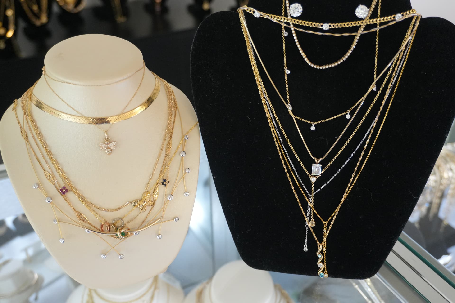 Two busts of layered gold chains with bee, diamond and gemstone pendants