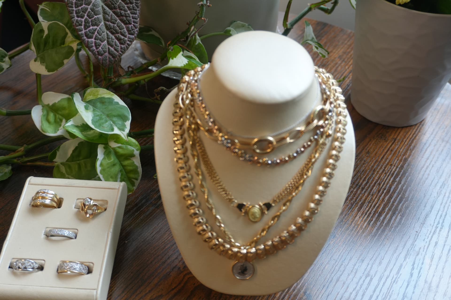 Gold chains and diamond rings arranged on a wooden counter