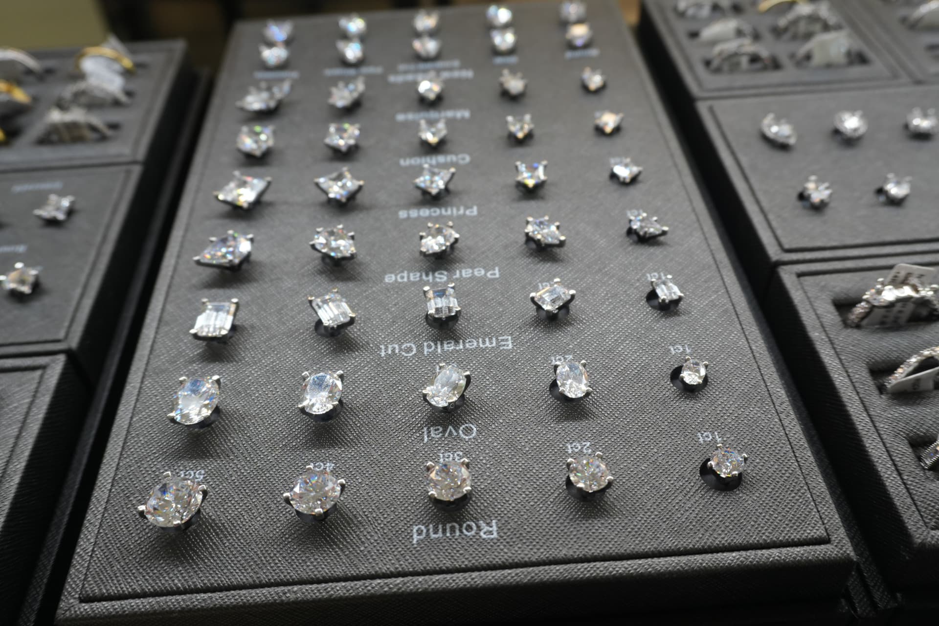 Diamond stud display showing round, oval, emerald, pear, princess and cushion cuts