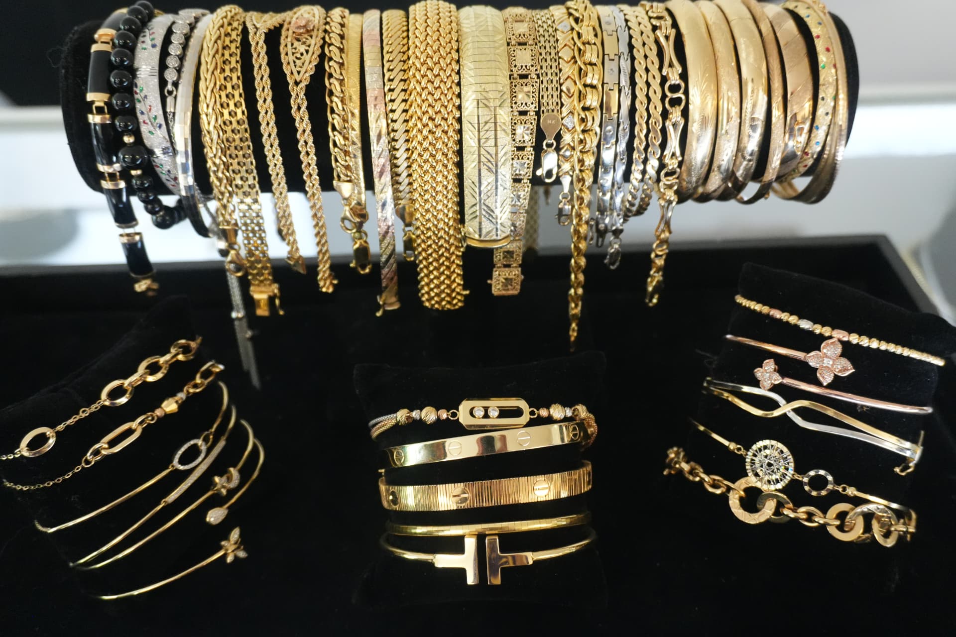 Gold bangles, cuffs and link bracelets arranged on black velvet