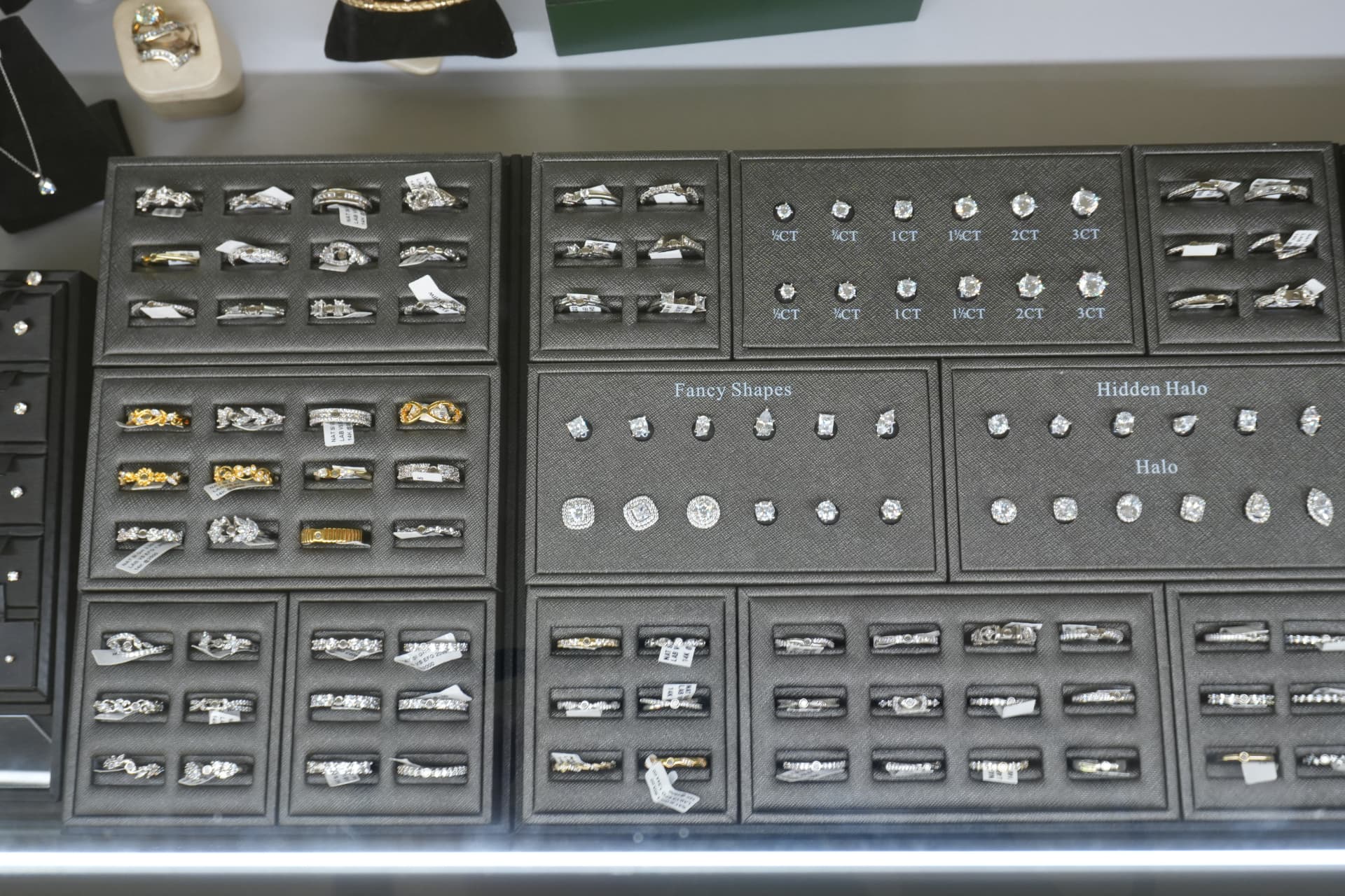 Engagement ring and diamond stud trays showing carat sizes and halo settings
